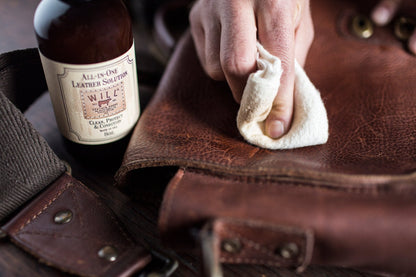 All-In-One Leather Solution by Will Leather Goods cleans brown leather with white cloth on Tampa Home & Garden Store