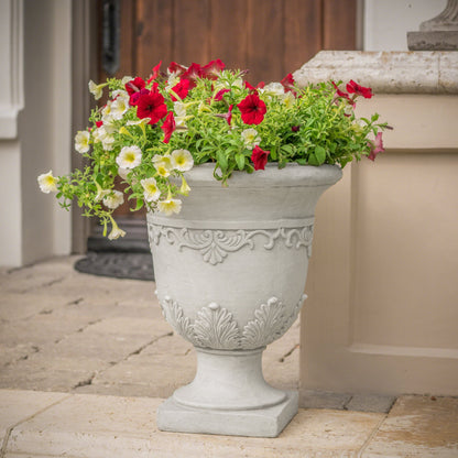 Moroccan Urn Planter in gray concrete with ornate relief and red, white and yellow petunias on Tampa Home & Garden Store