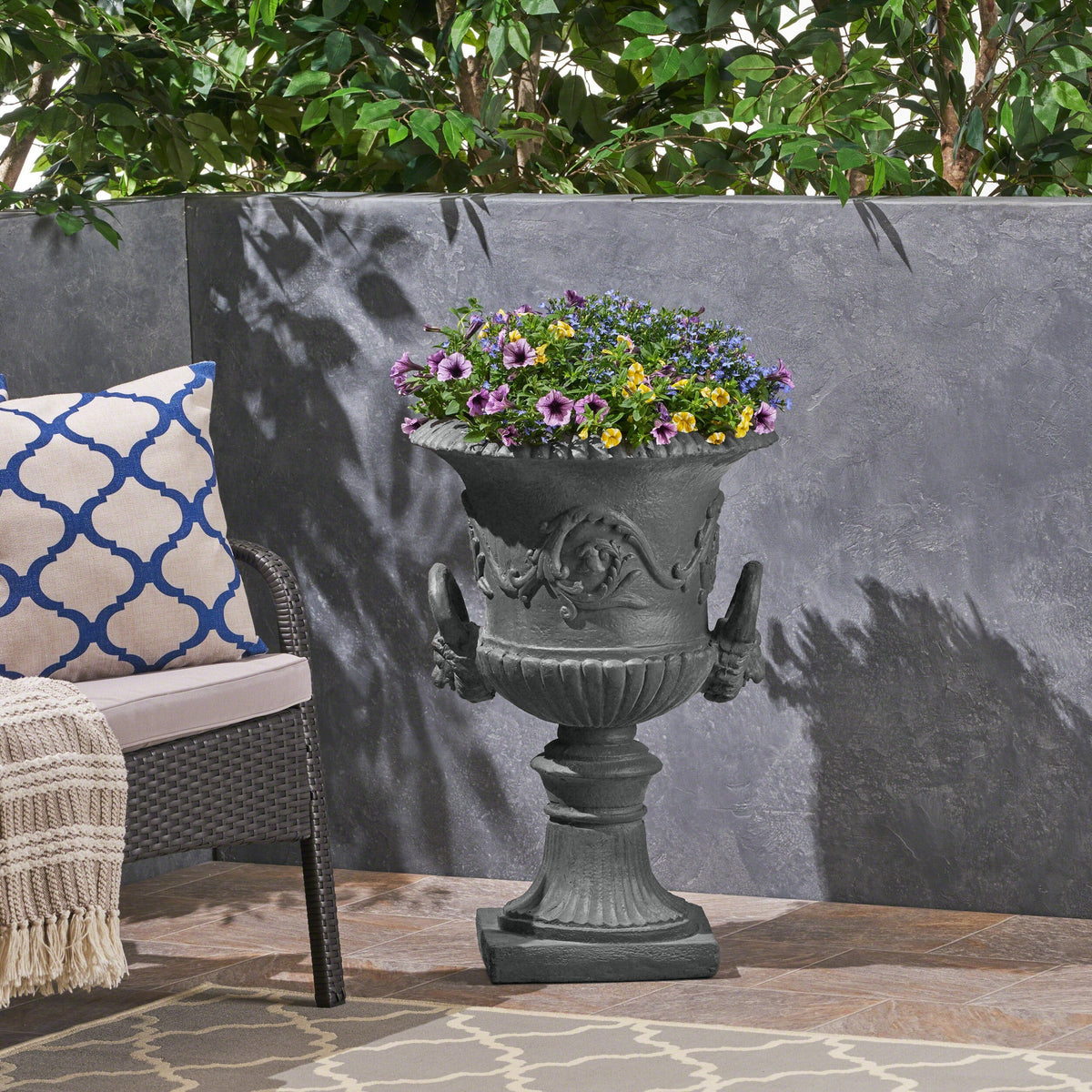 MGO Garden Urn Planter gray stone finish filled with purple, yellow, and blue flowers on Tampa Home & Garden Store