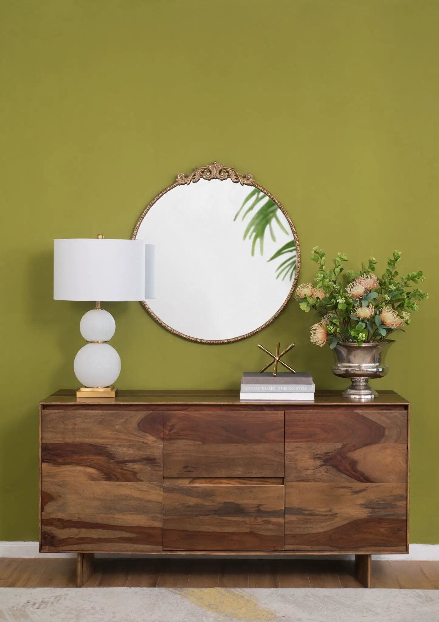 Classic design round wall mirror with gold Baroque frame leaning on a console against a wall on Tampa Home & Garden Store