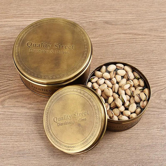 Vintage brass storage can set with Quality Street lid; open tin shows pistachios decorative jars on Tampa Home & Garden Store