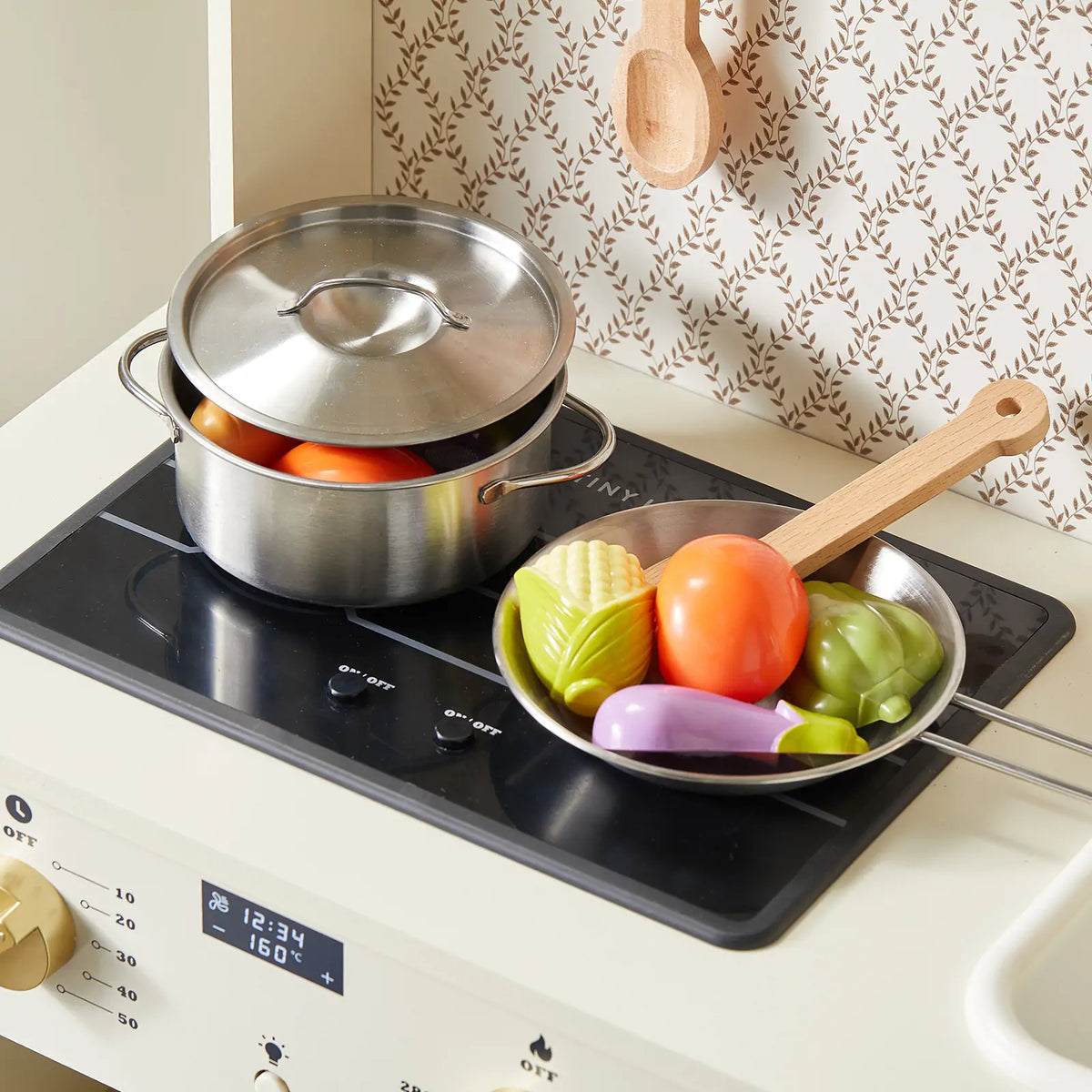 Tiny Land PopJoy Play Kitchen metal pots and a colorful vegetable set on stove spatula nearby on Tampa Home & Garden Store