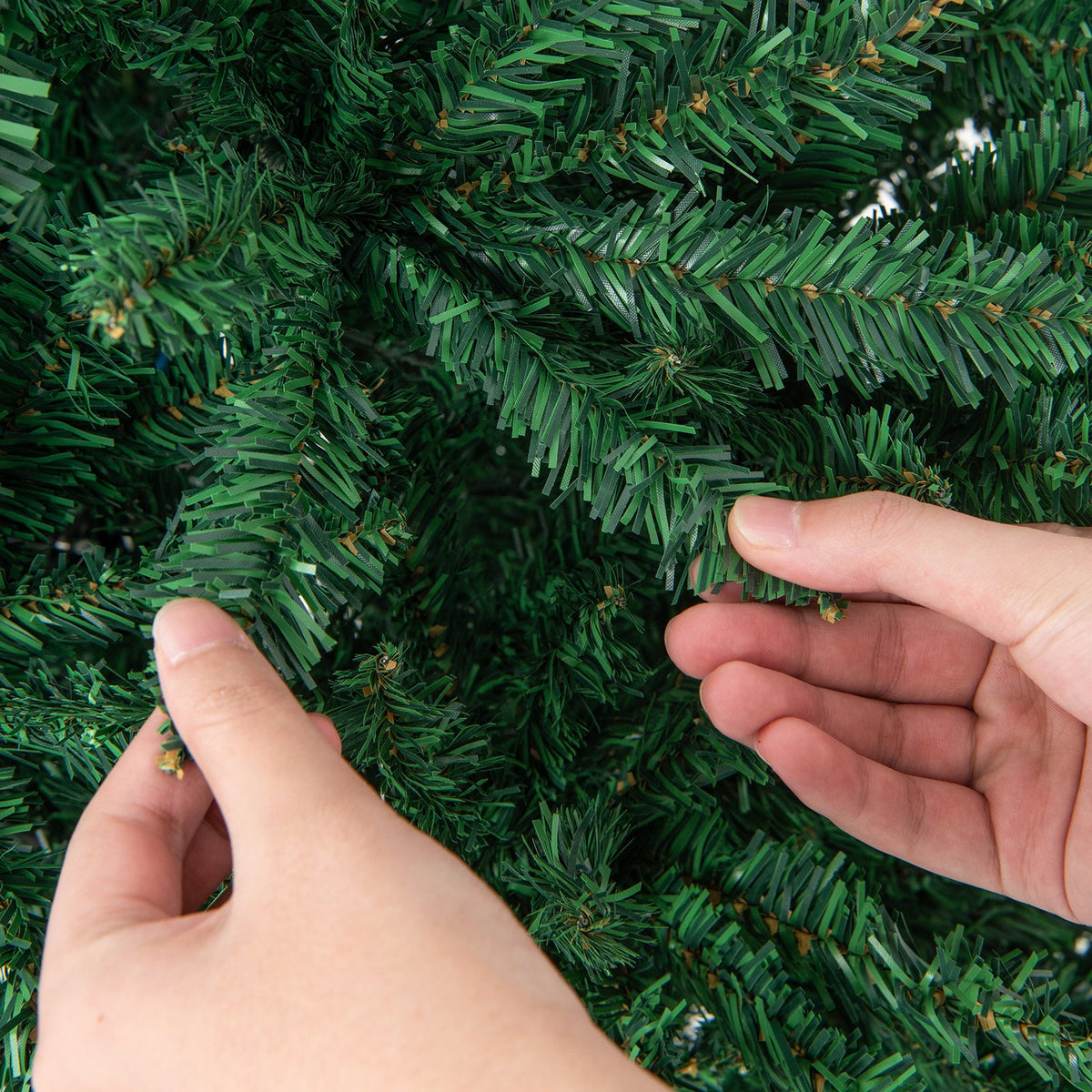 9 Feet Hinged Premium Artificial PVC Christmas Tree with green branches being shaped by hands on Tampa Home & Garden Store