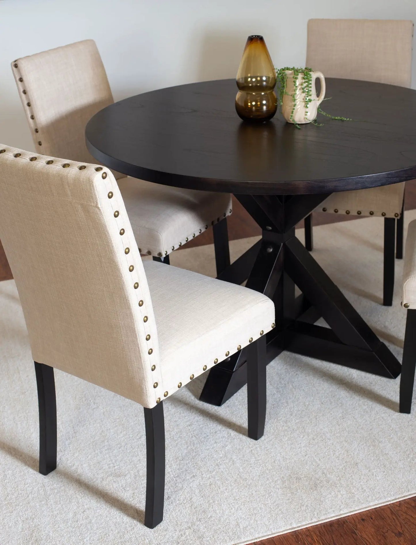 Mytzi 5 Piece Dining Set round black cross-buck table with four beige upholstered chairs on Tampa Home & Garden Store