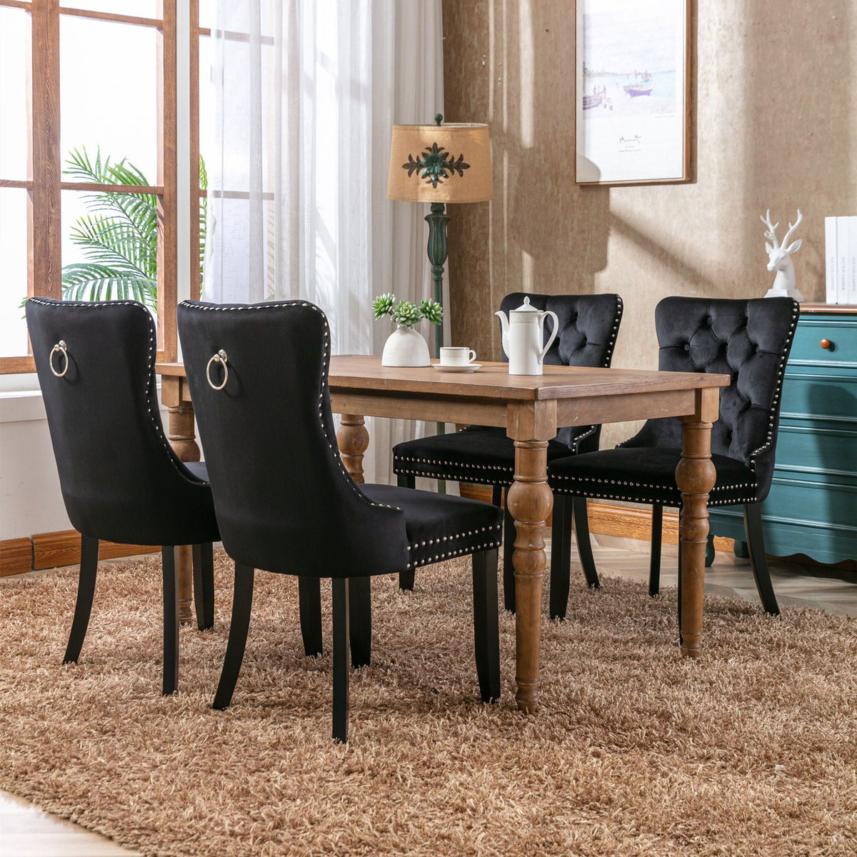 Tufted dining chair set in black velvet with nailhead trim, four chairs around a wood table on Tampa Home & Garden Store