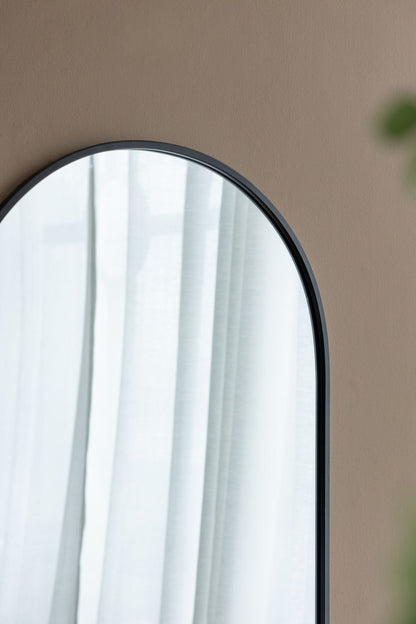 Arched metal-frame wall mirror in black with white curtains on tan wall HouseOfZazla on Tampa Home & Garden Store