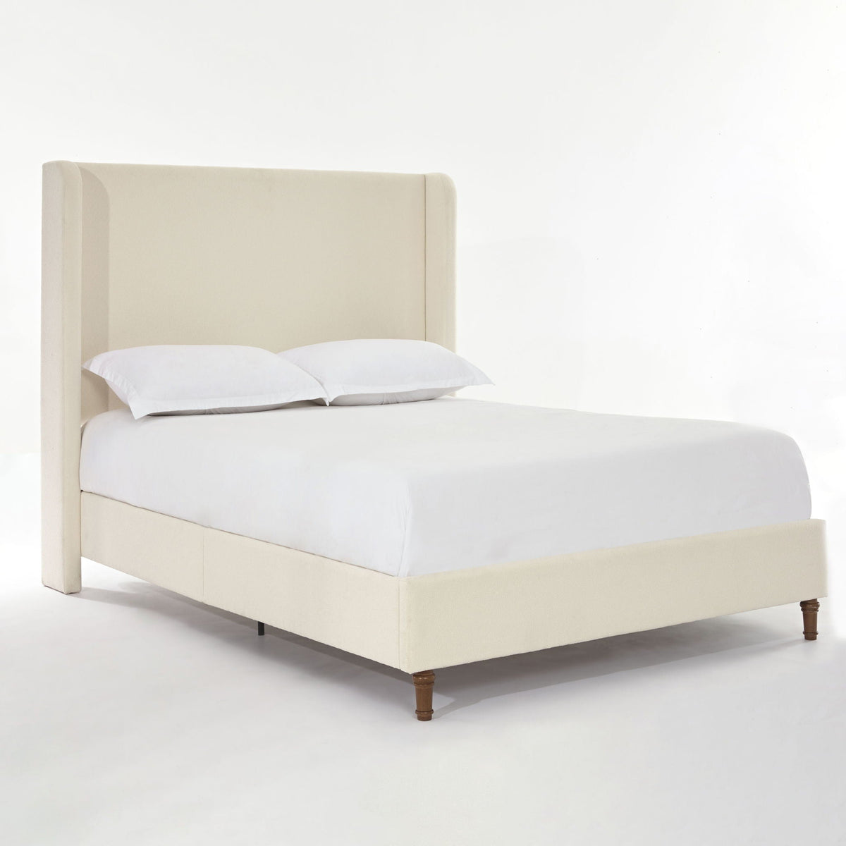 Harper tall upholstered bed in beige fabric with curved headboard and wooden legs on Tampa Home & Garden Store