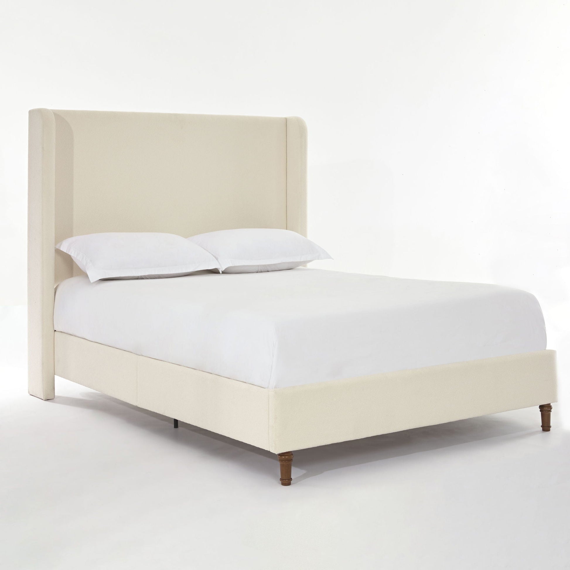 Harper tall upholstered bed in beige fabric with curved headboard and wooden legs on Tampa Home & Garden Store