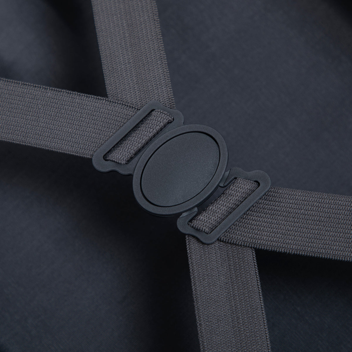 Luggage strap close-up on dark fabric showing gray woven strap and plastic buckle on Tampa Home & Garden Store