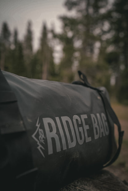 Ridge Bag medium outdoor duffel in dark gray nylon with RIDGE BAG logo on outdoor ground on Tampa Home & Garden Store
