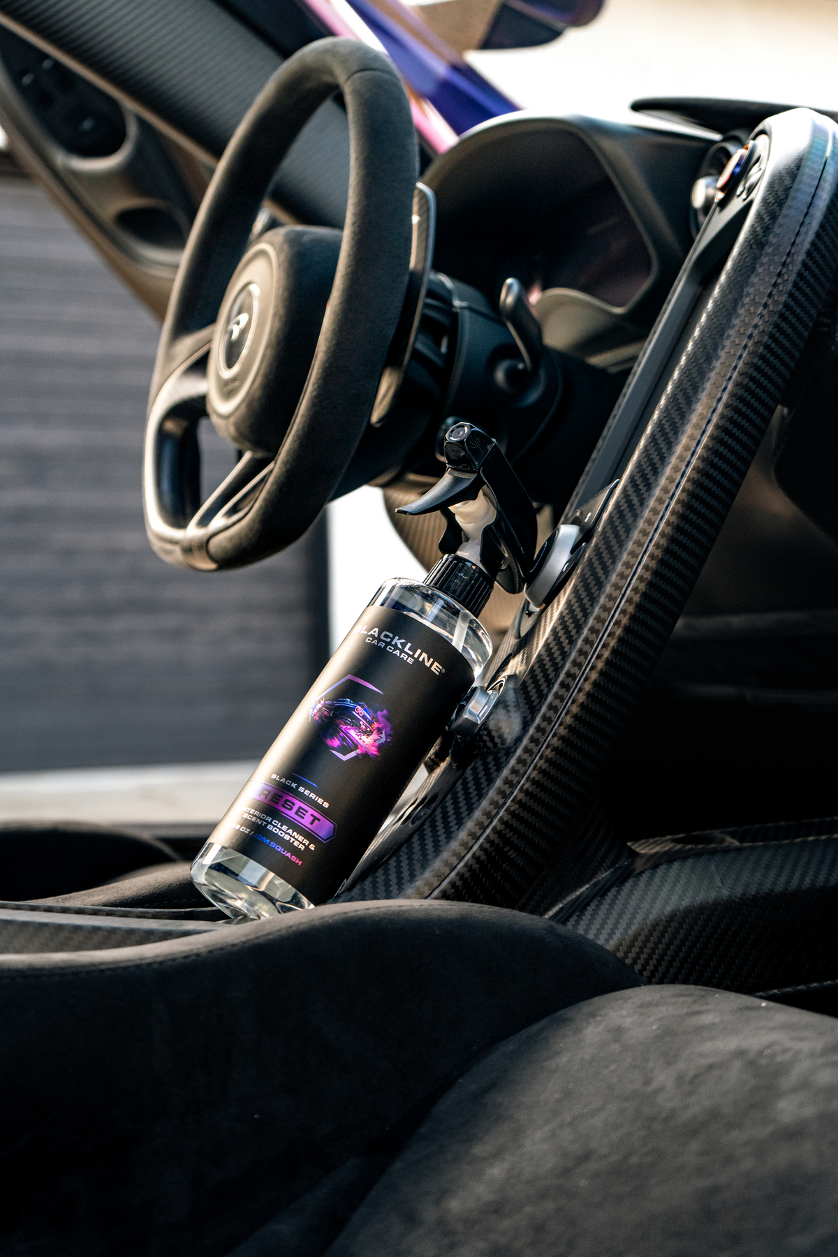 Blackline Reset Interior Cleaner spray bottle on a carbon fiber car dashboard with steering wheel on Tampa Home & Garden Store