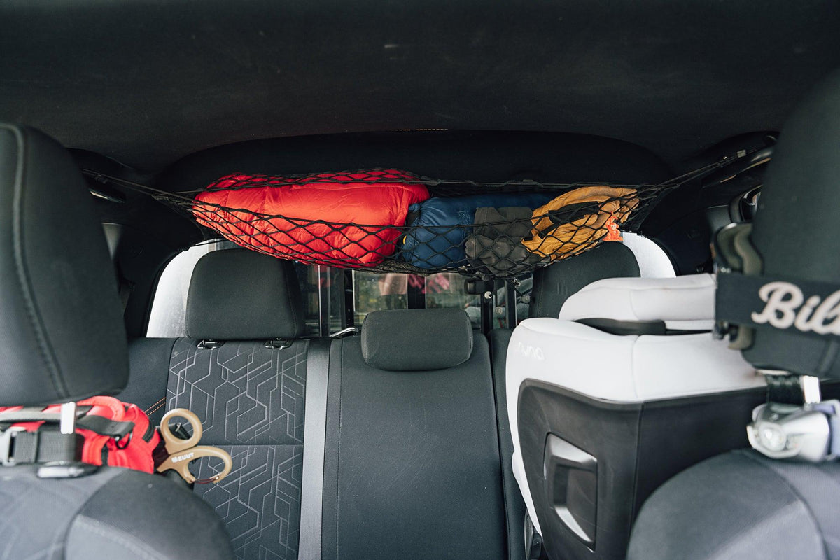 Flatirons Overland Toyota Tacoma Attic Storage Net in black, secures red and blue bags in SUV on Tampa Home & Garden Store