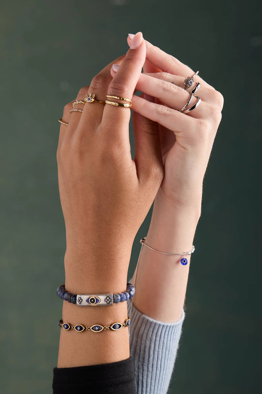 Evil Eye Pull Chain Bracelet by ALEX AND ANI, stacked with blue beads and silver bangles on Tampa Home & Garden Store