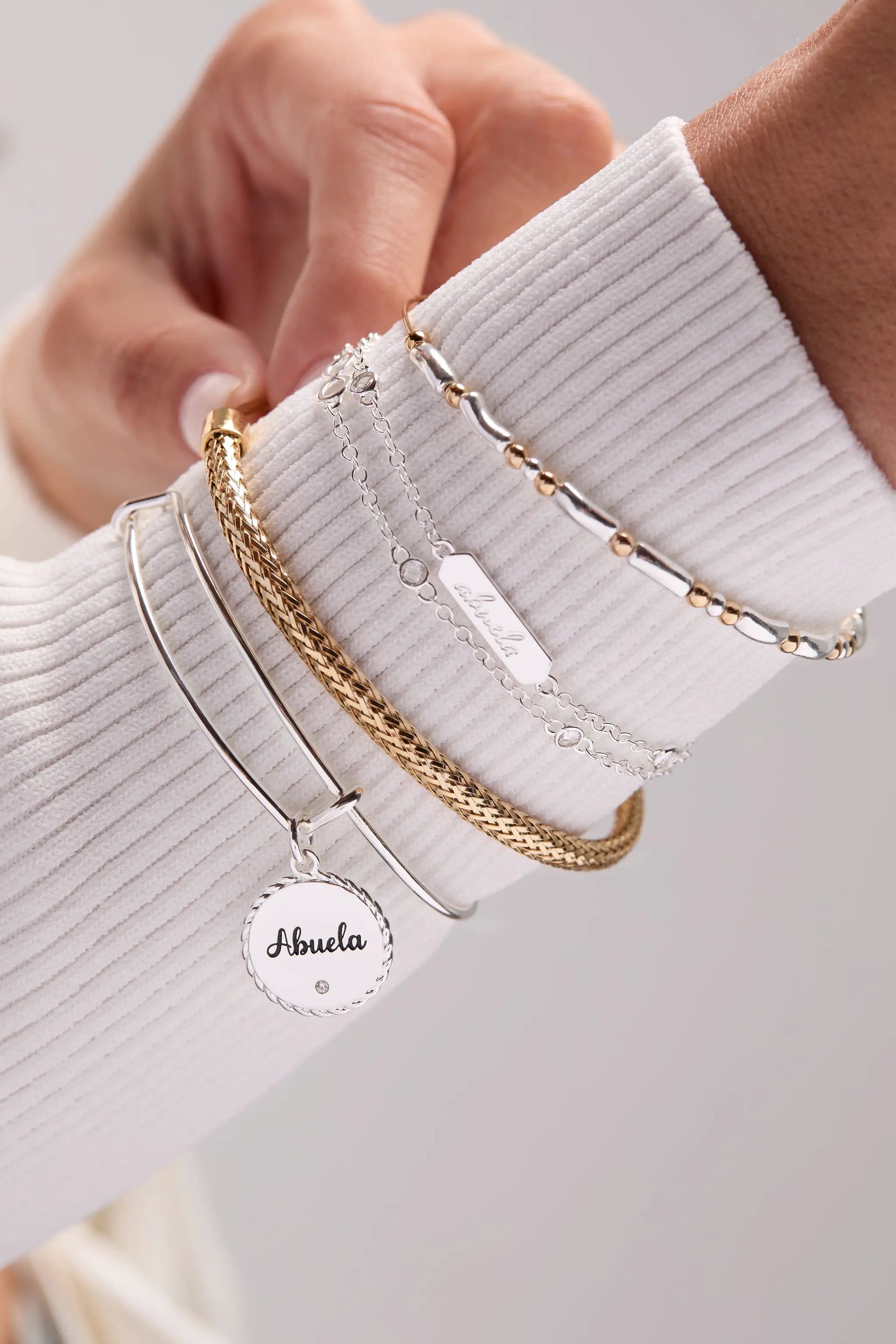 Abuela Infinity Chain Double Strand Bracelet with Abuela charm and gold-tone links stacked on Tampa Home & Garden Store