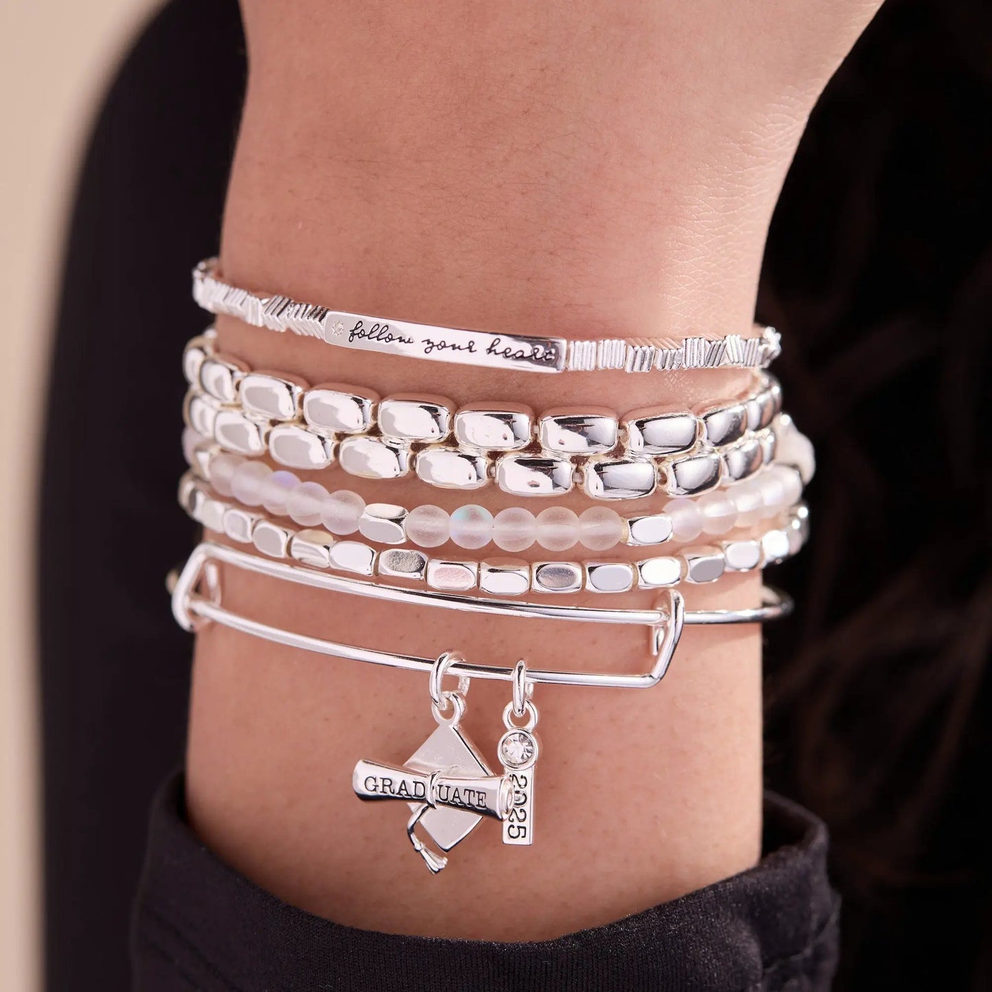 Follow Your Heart stretch bracelet by Alex and Ani on wrist with stacked silver-tone bracelets on Tampa Home & Garden Store