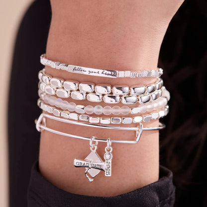 Follow Your Heart stretch bracelet by Alex and Ani on wrist with stacked silver-tone bracelets on Tampa Home & Garden Store