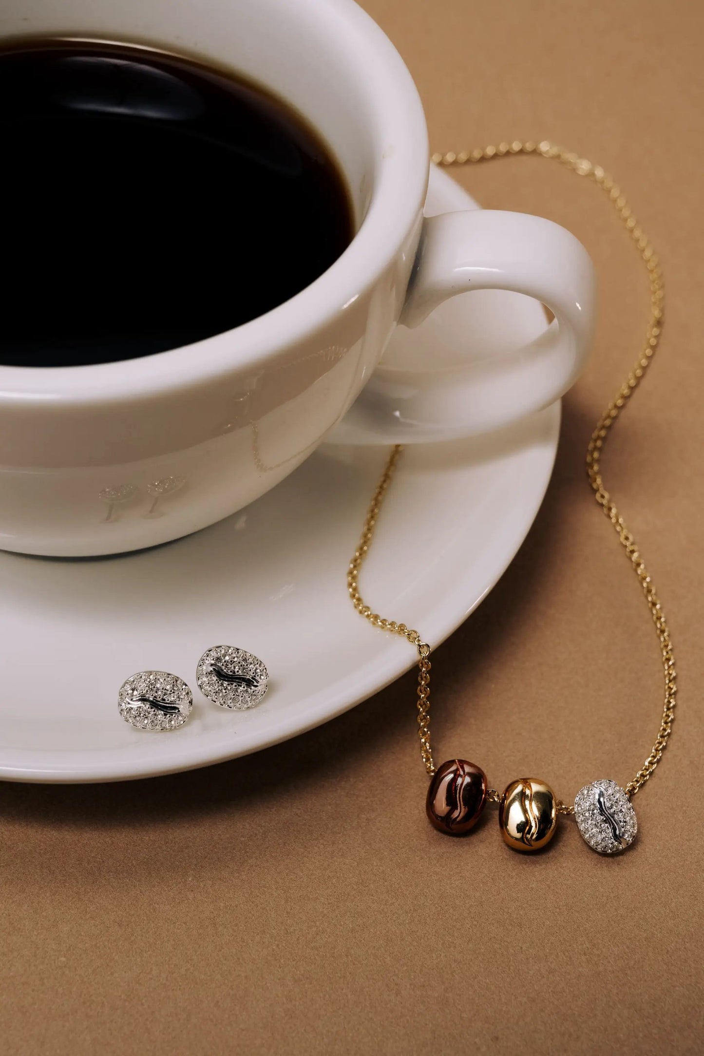 Coffee Bean engraved pendant necklace by Alex and Ani on gold-tone chain; crystal stud earrings on Tampa Home & Garden Store