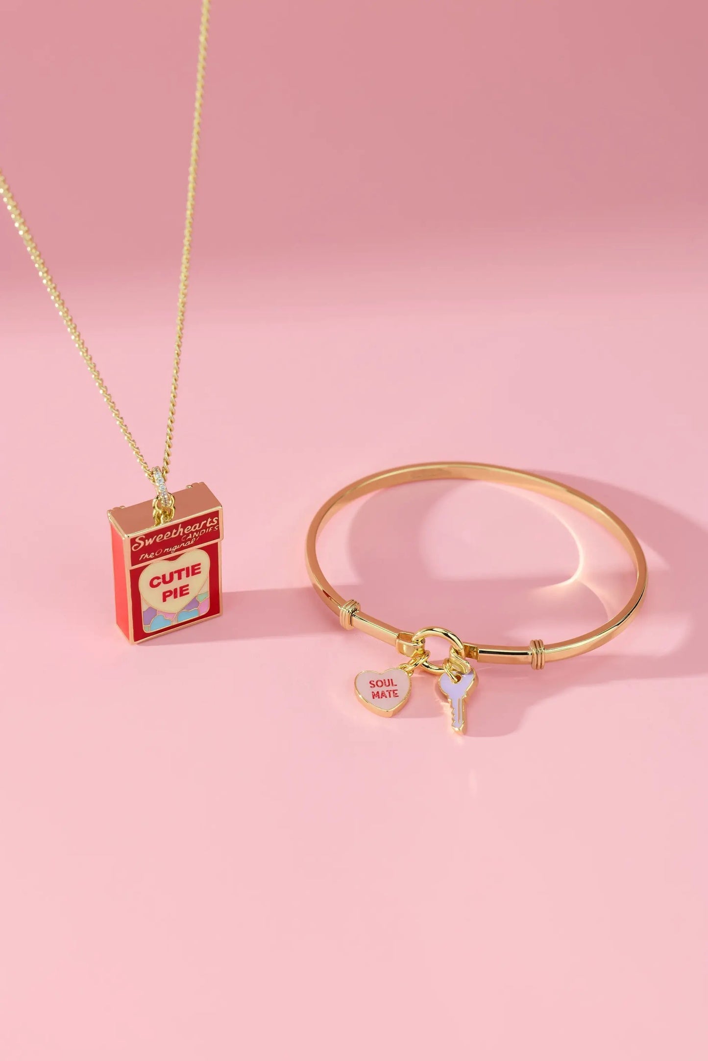 Sweethearts Box Locket Necklace on a gold chain beside a gold charm bracelet with soul mate heart and key charms on Tampa Home & Garden Store