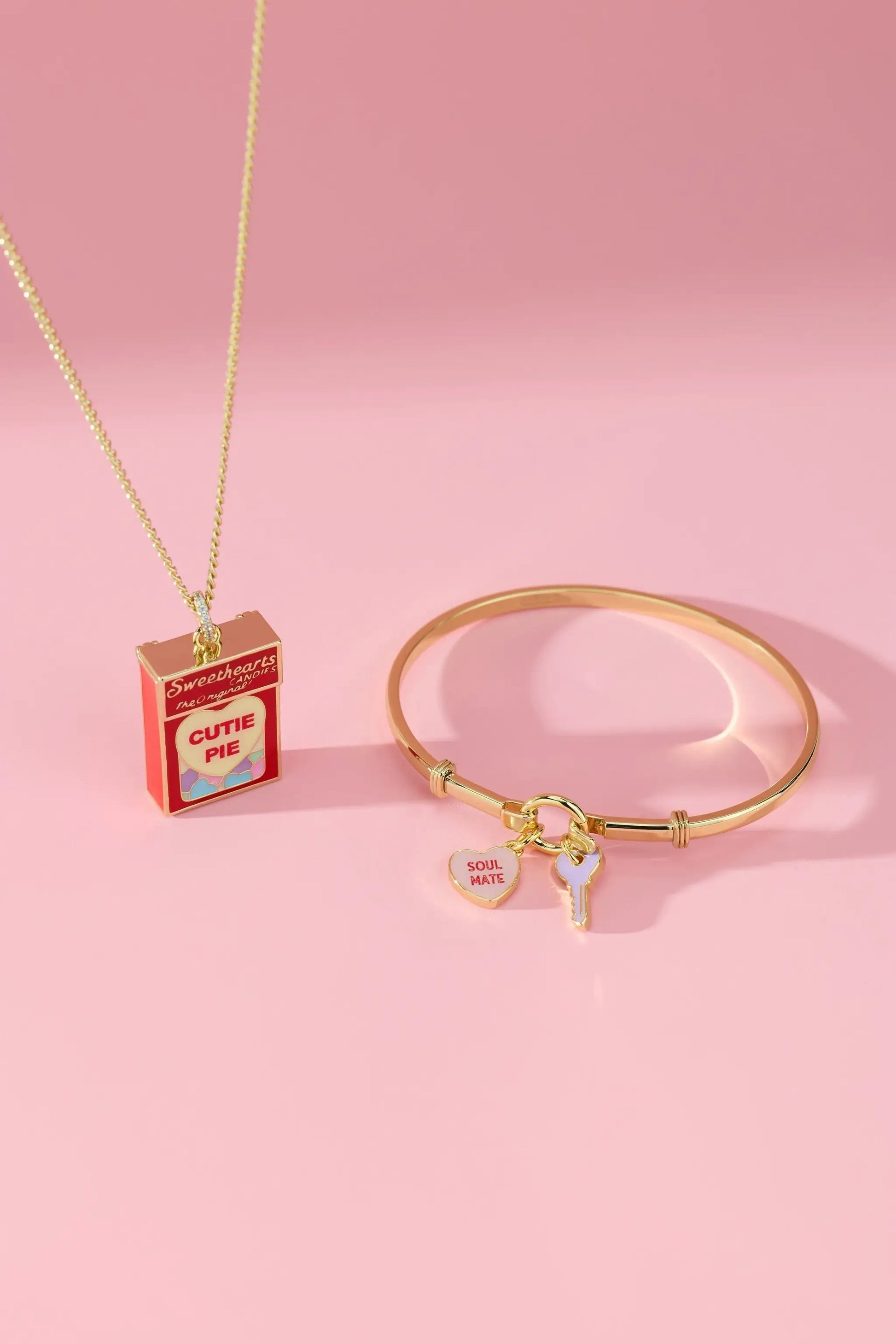 Sweethearts Box Locket Necklace on a gold chain beside a gold charm bracelet with soul mate heart and key charms on Tampa Home & Garden Store