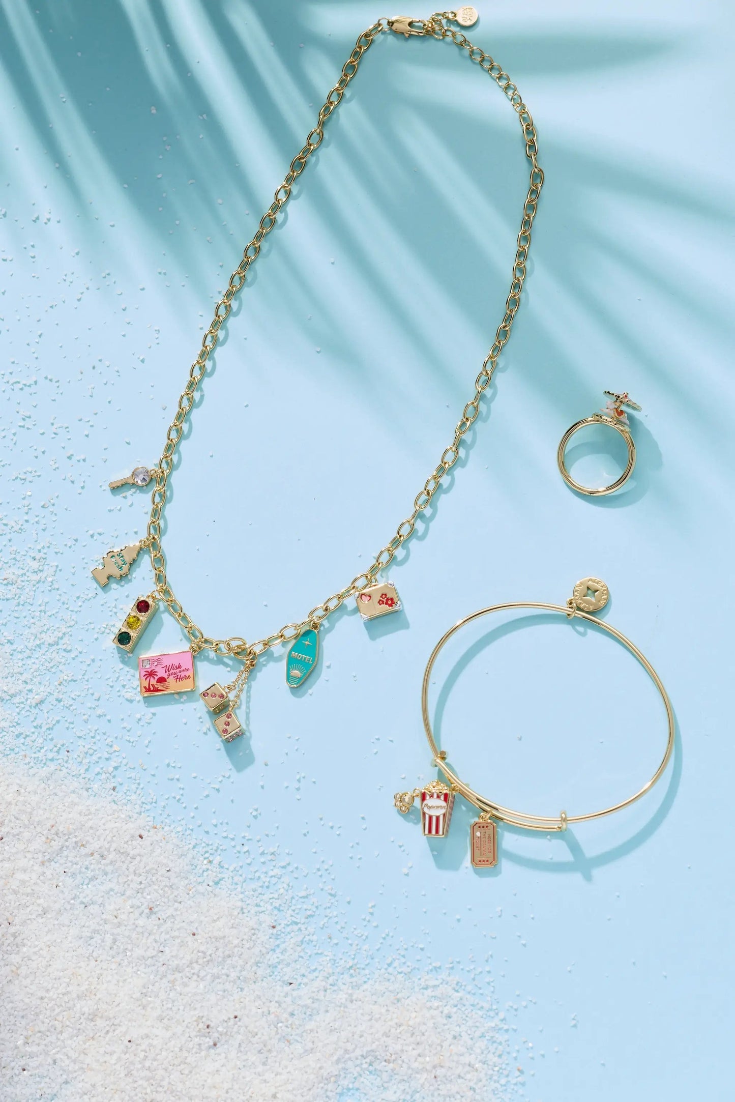 Road Trip Necklace by ALEX AND ANI, gold-tone chain with travel charms on blue background on Tampa Home & Garden Store