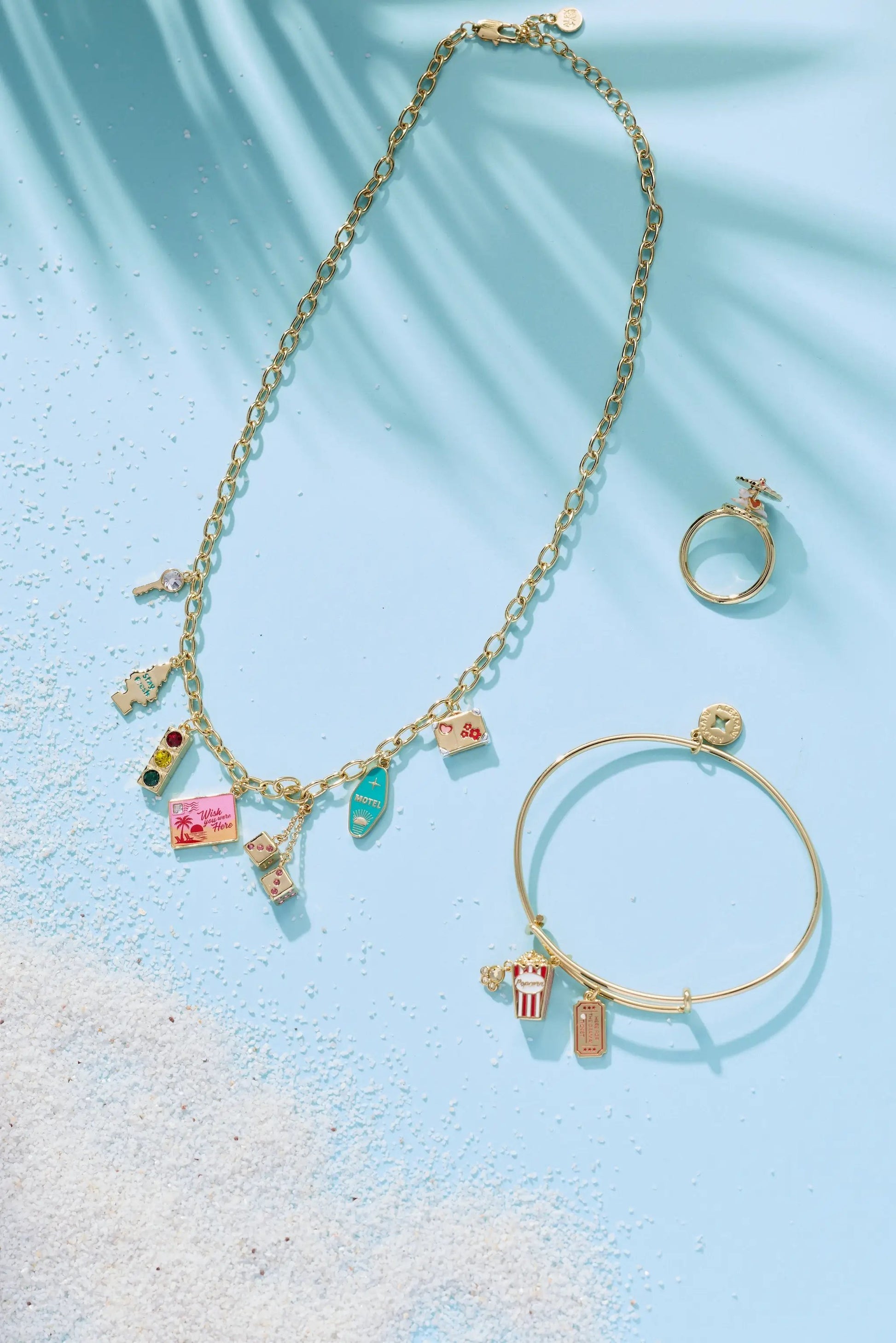 Road Trip Necklace by ALEX AND ANI, gold-tone chain with travel charms on blue background on Tampa Home & Garden Store