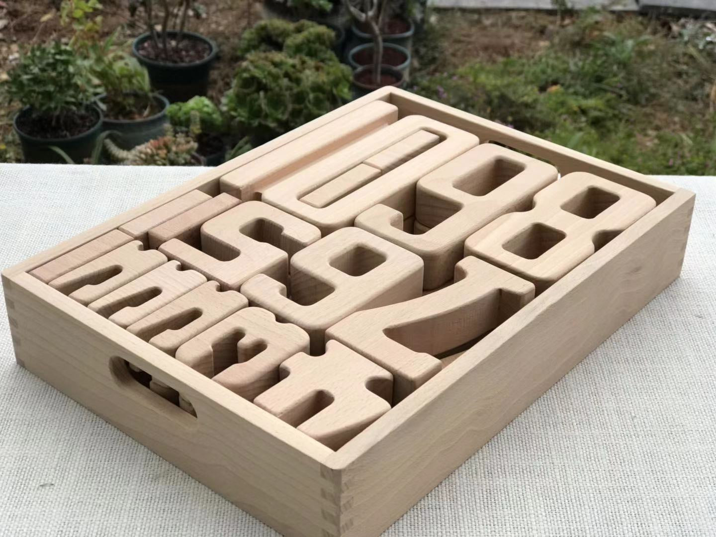 Montessori wooden building blocks set in natural wood with cutout shapes in a wooden tray on Tampa Home & Garden Store
