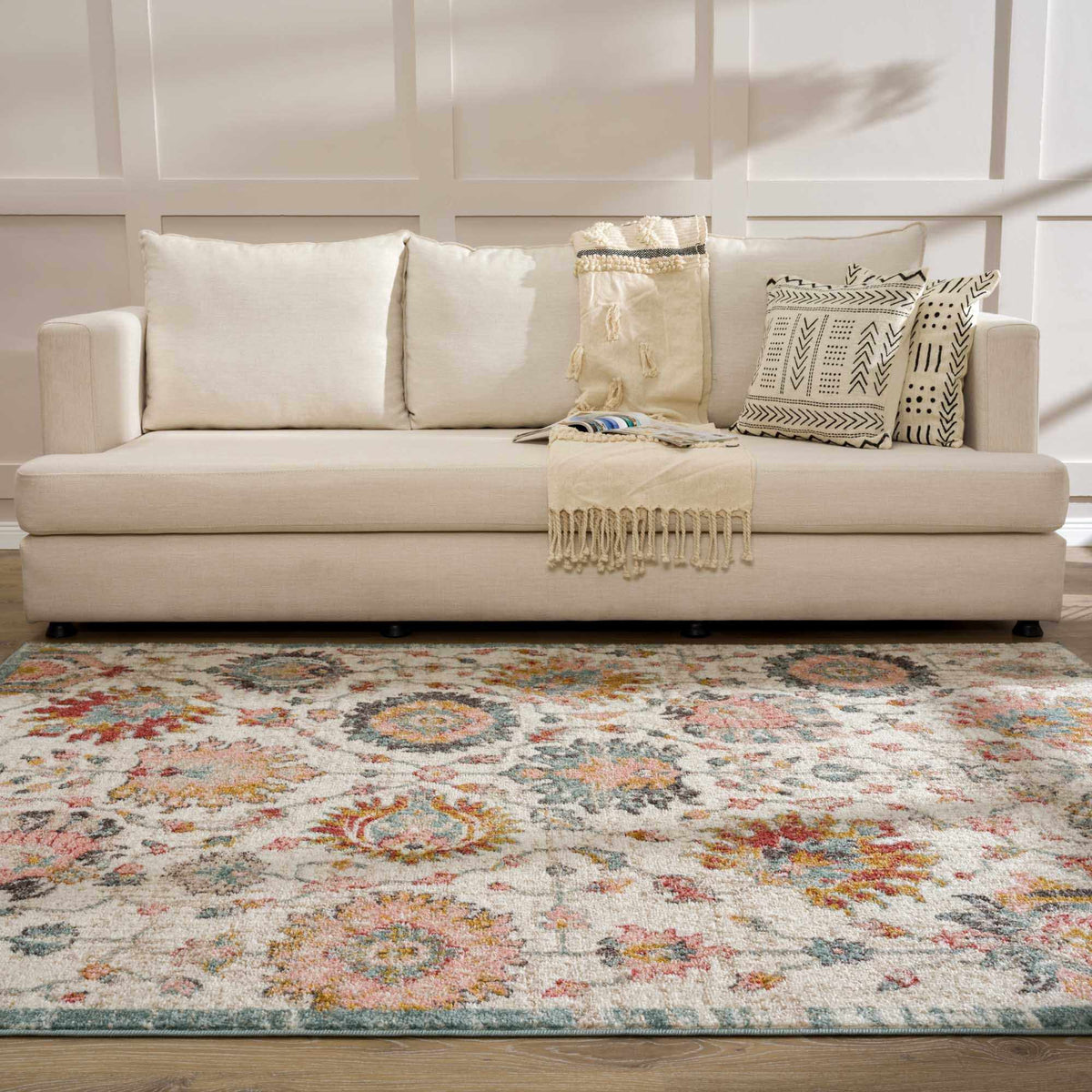 Twilight Floral Area Rug cream with multicolor floral pattern under a beige sofa on Tampa Home & Garden Store