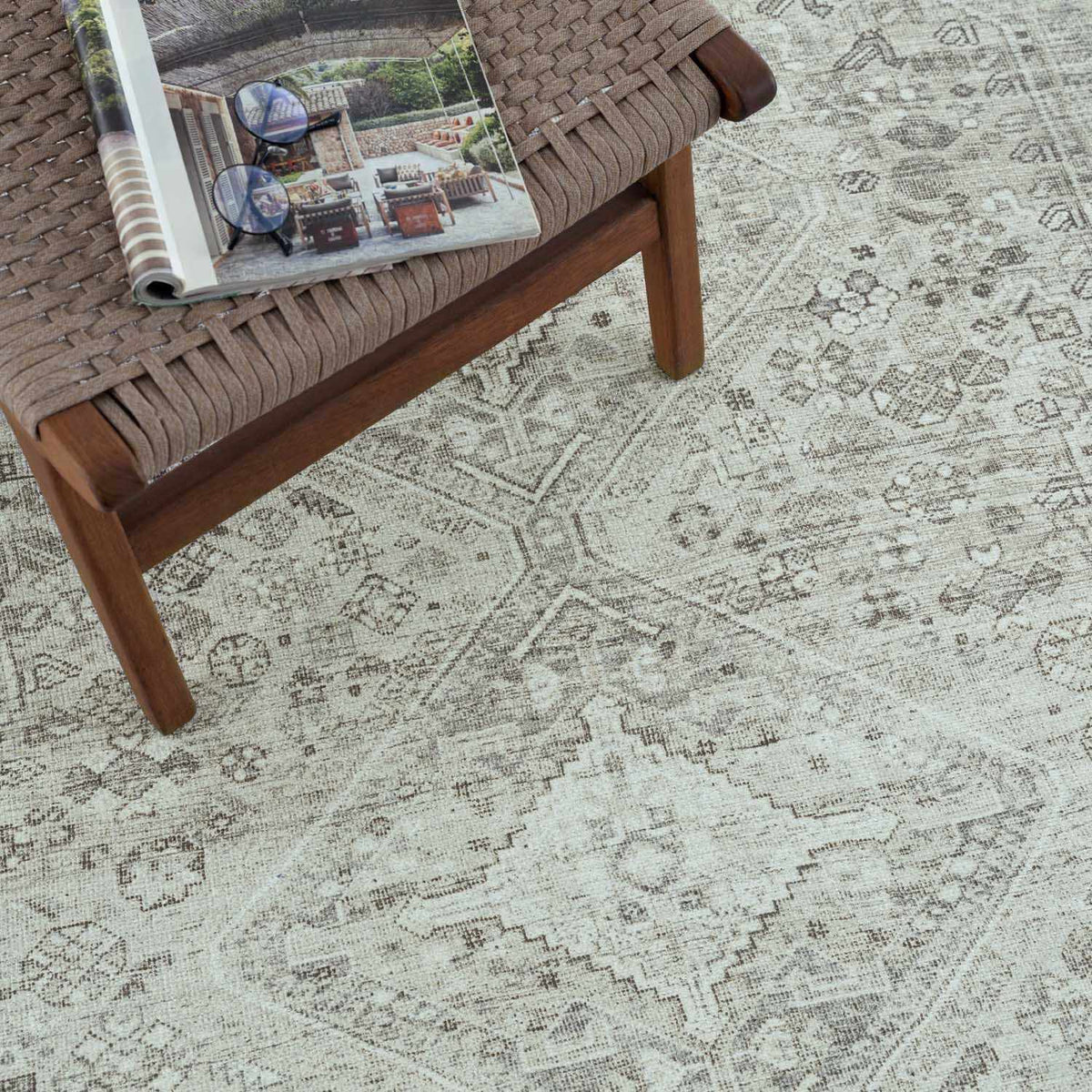 Barny Sage flat-pile washable rug on a woven brown bench with a pale distressed pattern on Tampa Home & Garden Store