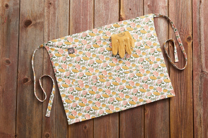 Gardener's Half Apron by Womanswork, floral pink print with ties; pair of yellow gloves on Tampa Home & Garden Store