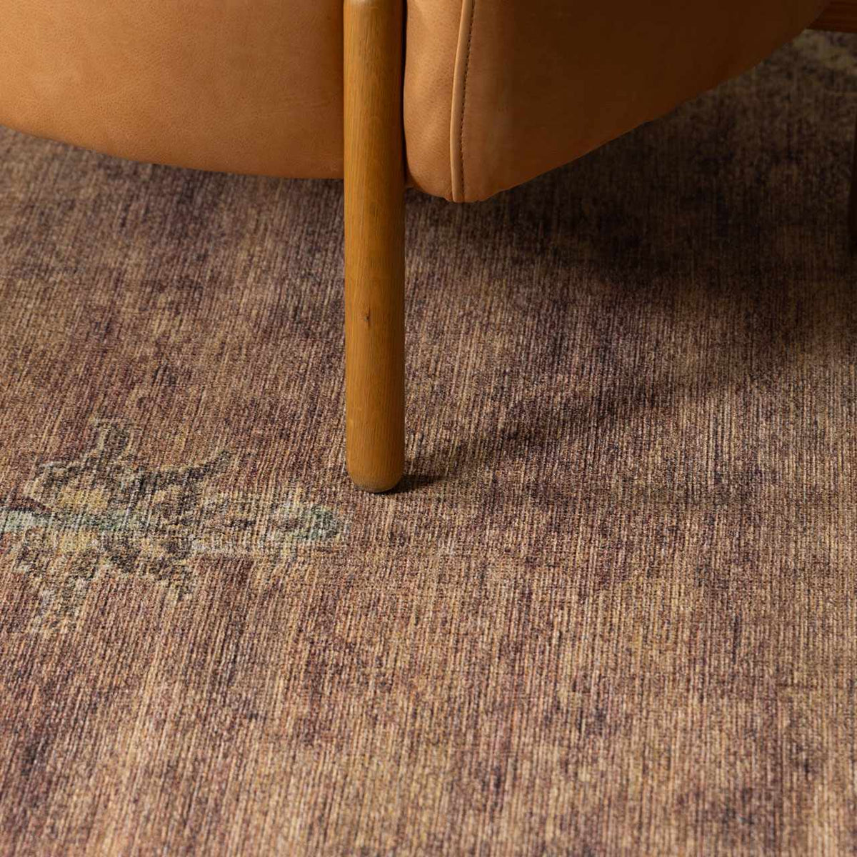 Powhatan washable area rug, brown textured pattern under a wooden chair leg on Tampa Home & Garden Store