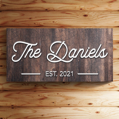Family Name Sign IV canvas plaque with rustic wood and white cursive The Daniels EST 2021 on Tampa Home & Garden Store