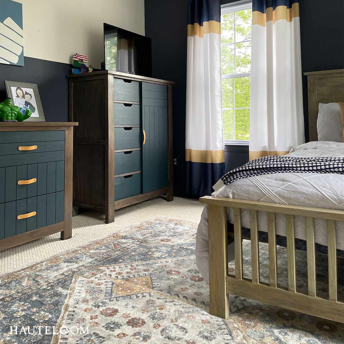 Afya Boutique Washable Rug in blue ivory orange tones in a navy bedroom with dark wood dressers on Tampa Home & Garden Store
