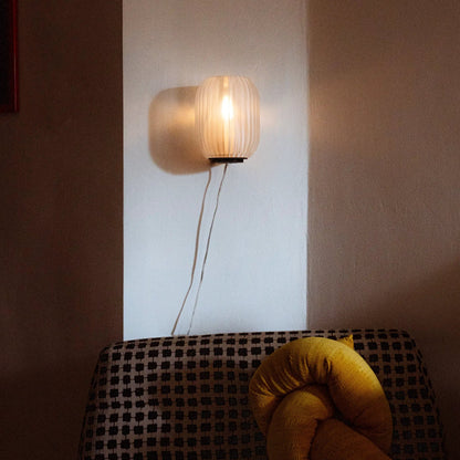 Allium Sconce wall light with cream pleated shade emits warm glow on wall on Tampa Home & Garden Store