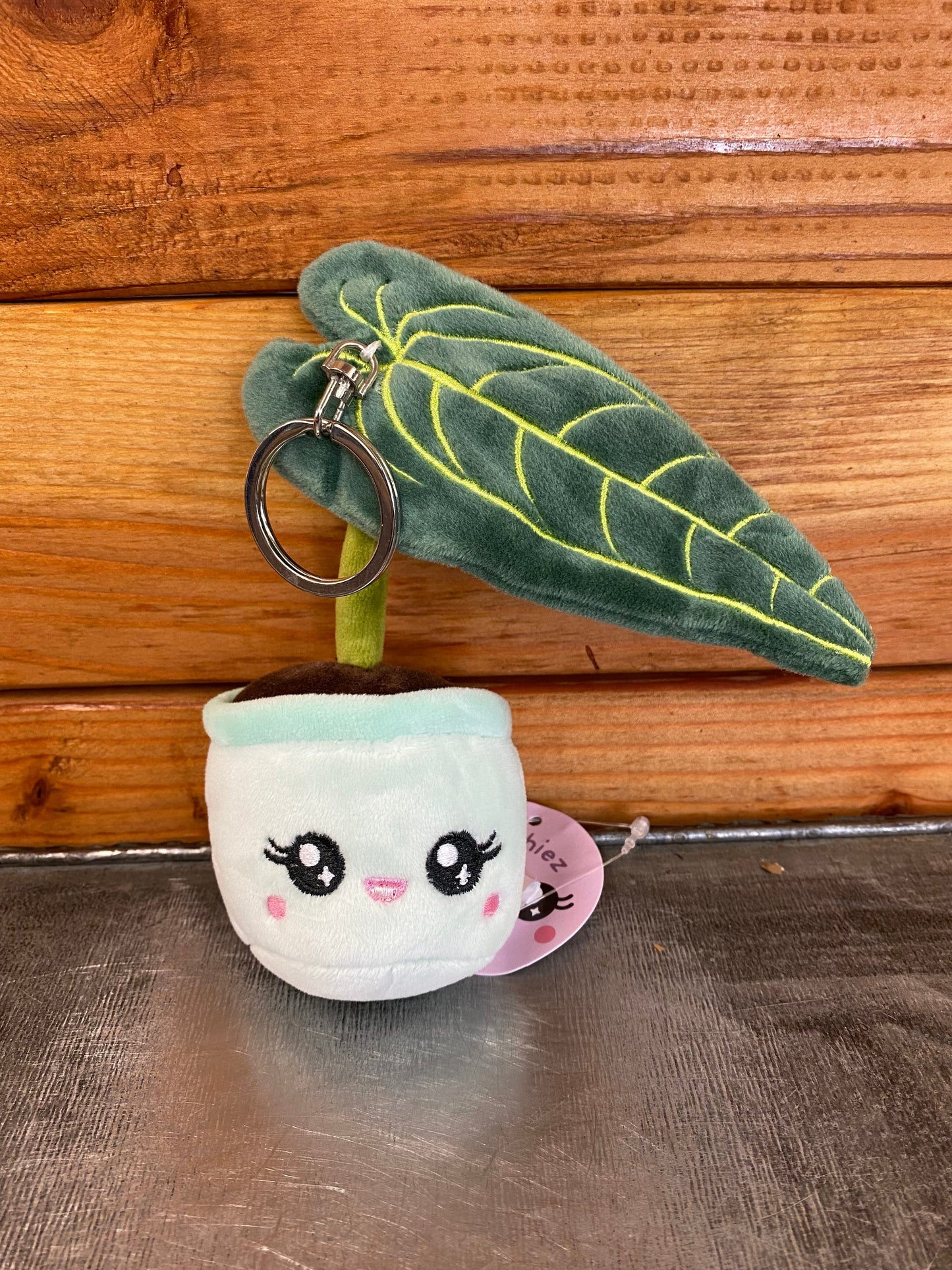 Plush keychain with a cute face design on a wooden surface