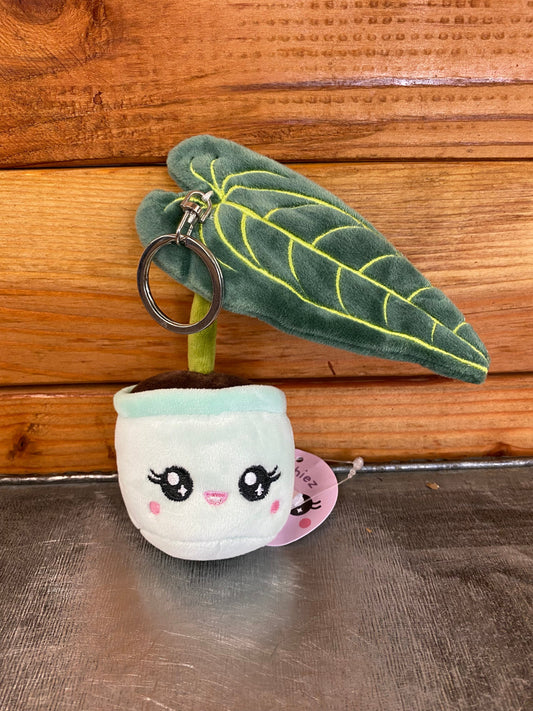 Plush keychain with a cute face design on a wooden surface