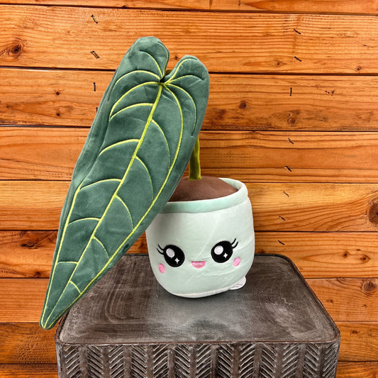 Cute plush plant with a pot against a wooden background
