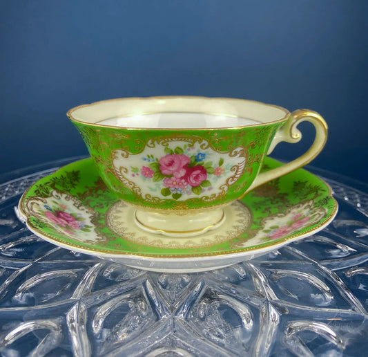 Antique green porcelain cup and saucer with gold trim and pink floral pattern, stacked on Tampa Home & Garden Store