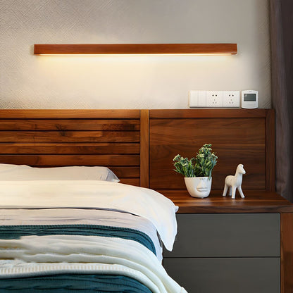 Pinea linear pine wood wall light with frosted diffuser, warm LED glow above bed on Tampa Home & Garden Store