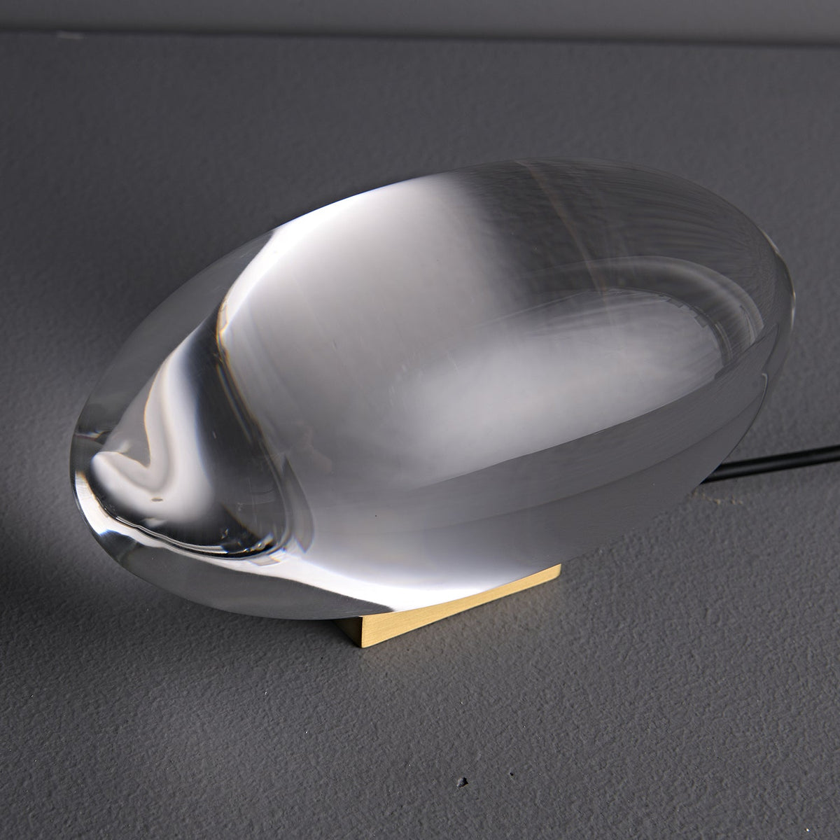 Seren crystal glass table lamp with curved teardrop silhouette resting on a wooden base on Tampa Home & Garden Store