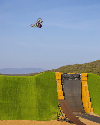 Slayco96 Explosion Knee Guard aerial motocross rider midair over ramp with green purple bike on Tampa Home & Garden Store