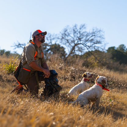 Training Collar Setup by Hoss Straps in outdoor hunting scene; kneeling hunter with two dogs wearing red collars on Tampa Home & Garden Store