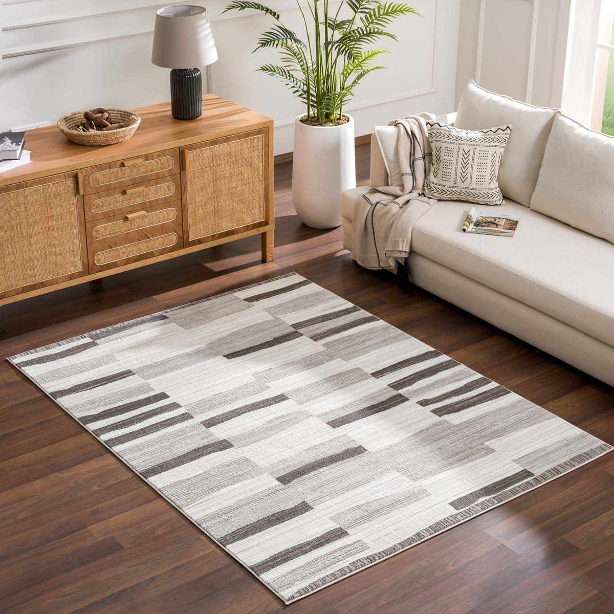 Bojana broken-striped area rug by Boutique Rugs in neutral grayscale tones on hardwood floor on Tampa Home & Garden Store