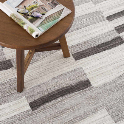 Boutique Rugs Bojana broken-striped area rug in beige gray under a wooden coffee table on Tampa Home & Garden Store