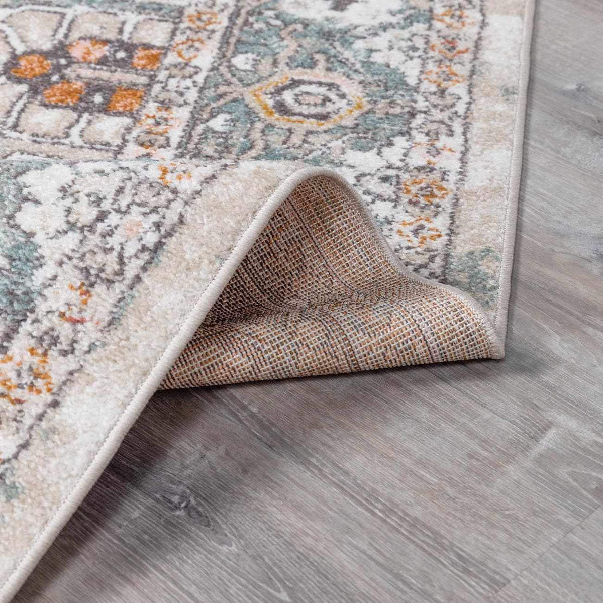 Bolinas Area Rug by Boutique Rugs in cream with teal orange medallion pattern on wood floor on Tampa Home & Garden Store