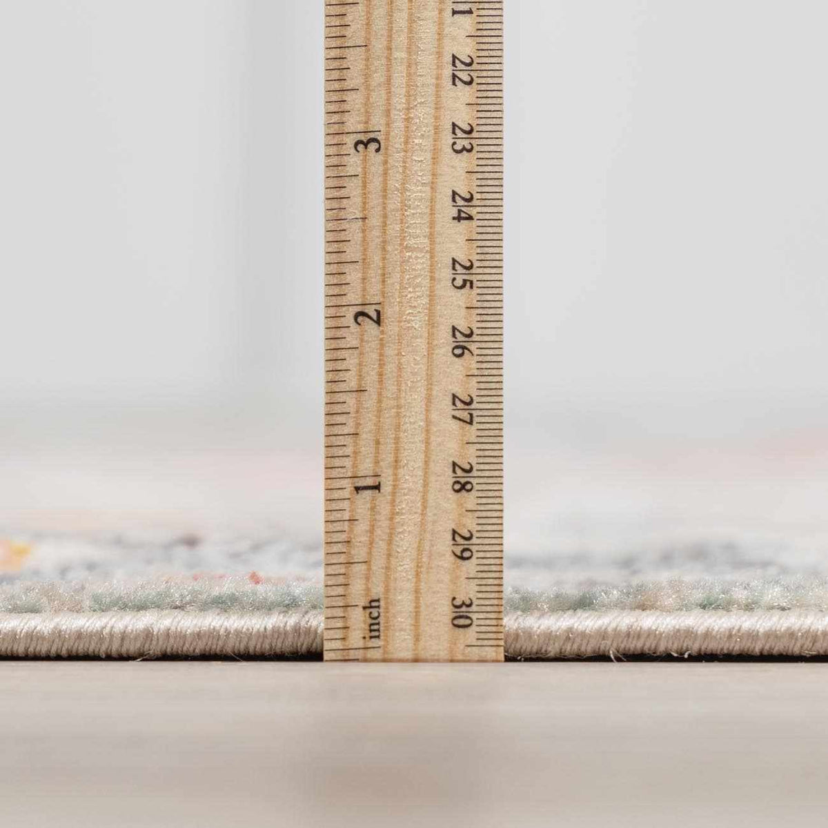 Bolinas area rug, soft beige tufted pile with subtle flecks, shown beside a measuring ruler on Tampa Home & Garden Store