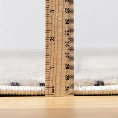 Burdette Soft Neutral Rug by Boutique Rugs, beige with subtle pattern and a ruler for scale on Tampa Home & Garden Store