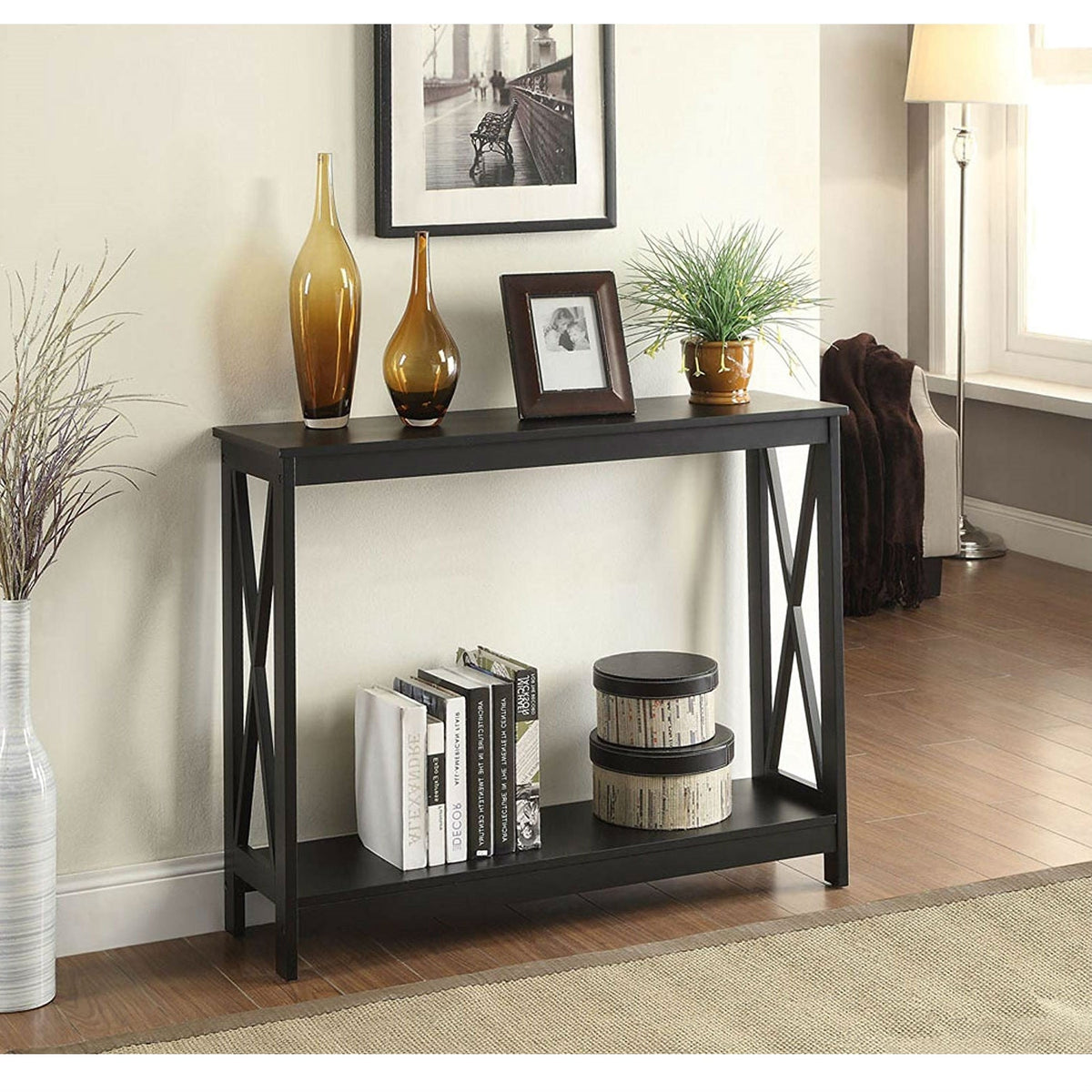 Black wood console sofa table with bottom shelf and X-leg frame; two amber vases top on Tampa Home & Garden Store