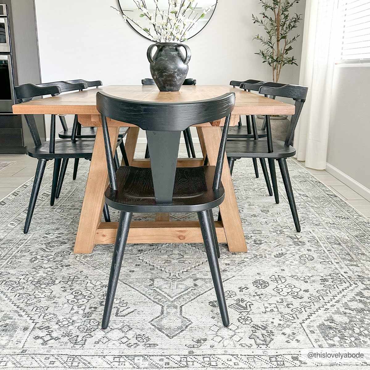 Barny Sage Flat Pile Washable Rug in sage gray under a wooden dining table with black chairs on Tampa Home & Garden Store