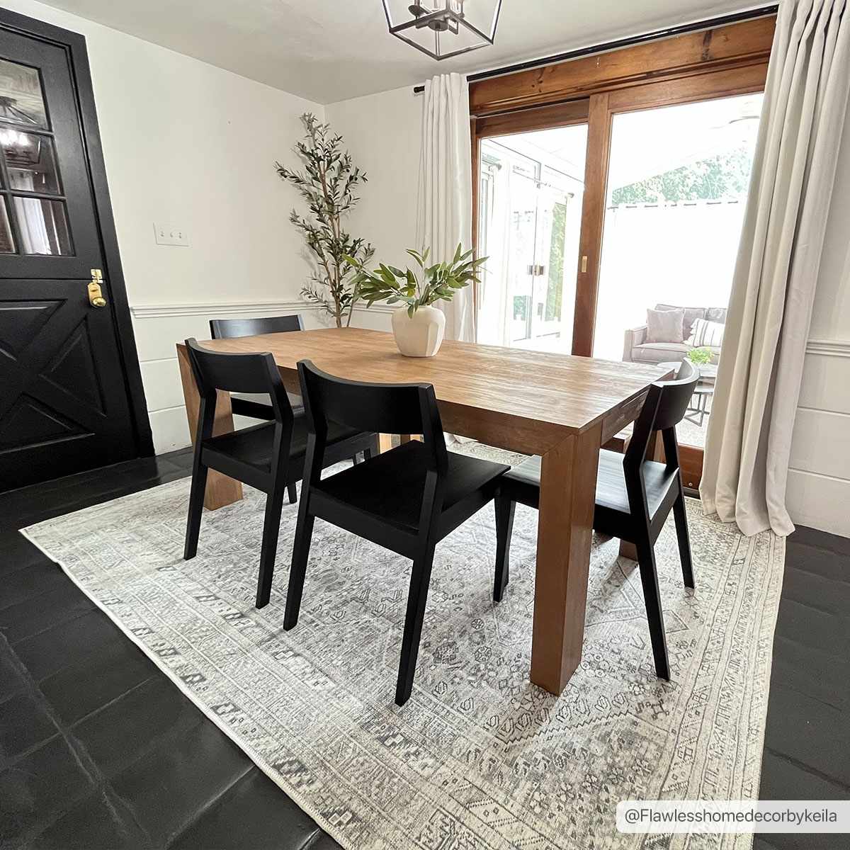 Barny Sage flat-pile washable rug by Boutique Rugs under a wooden dining table with black chairs on Tampa Home & Garden Store