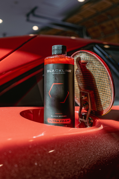 Blackline Car Care Ultra Foam car shampoo bottle with black label beside red car wheel on Tampa Home & Garden Store